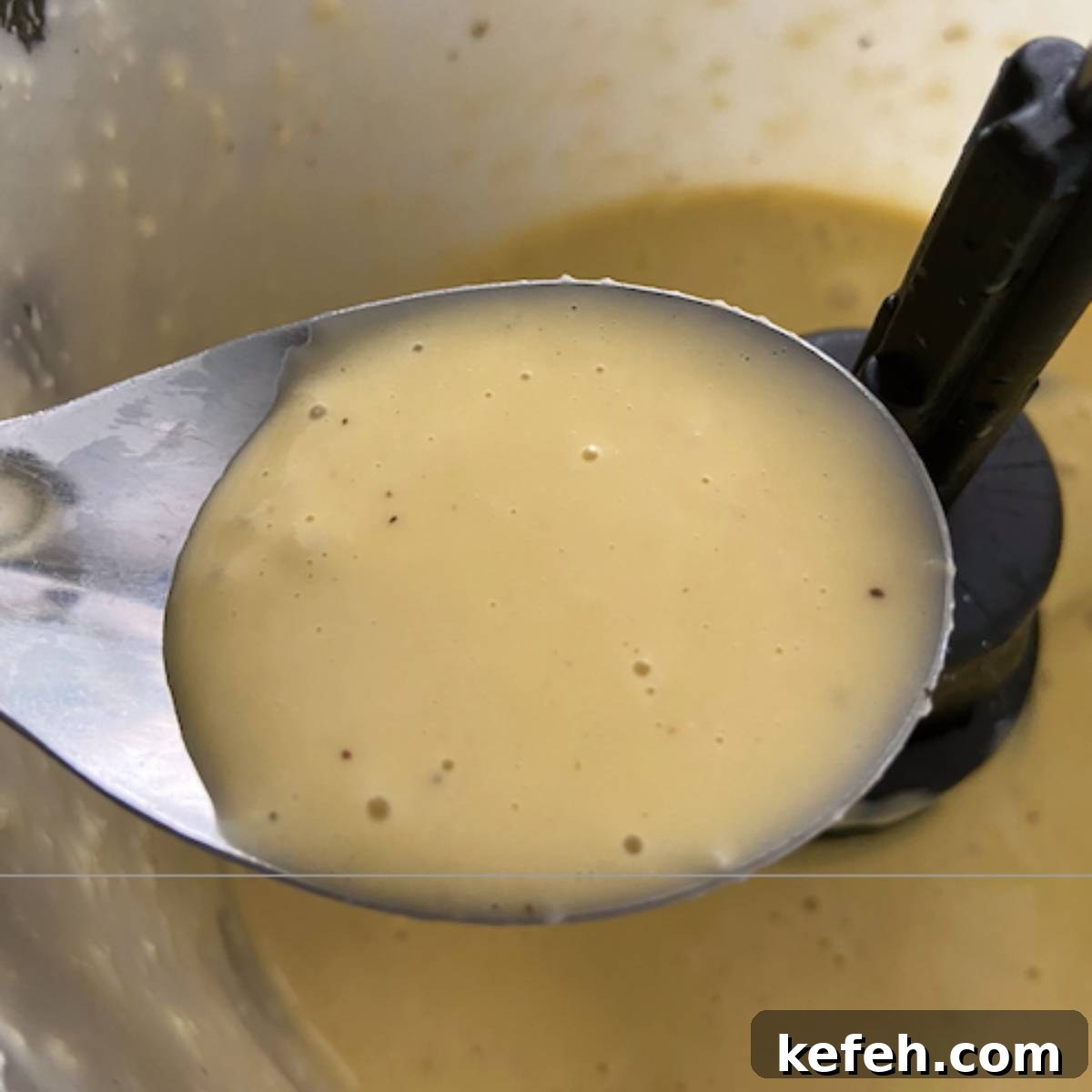 Creamy Caesar Salad Dressing Without Anchovies or Raw Eggs 7 Spoon holding finished salad dressing.