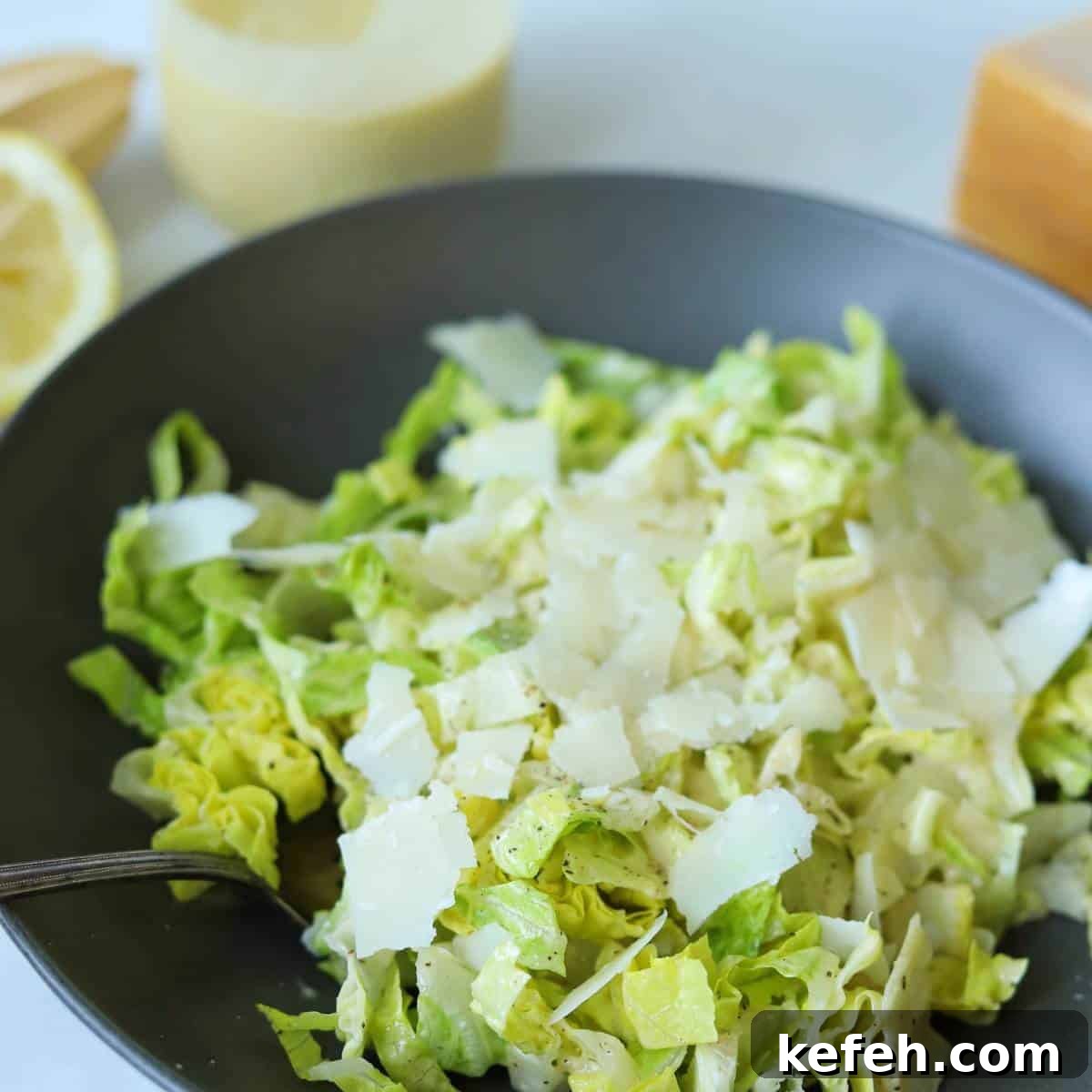 Creamy Caesar Salad Dressing Without Anchovies or Raw Eggs 9 Caesar salad in bowl with fork.
