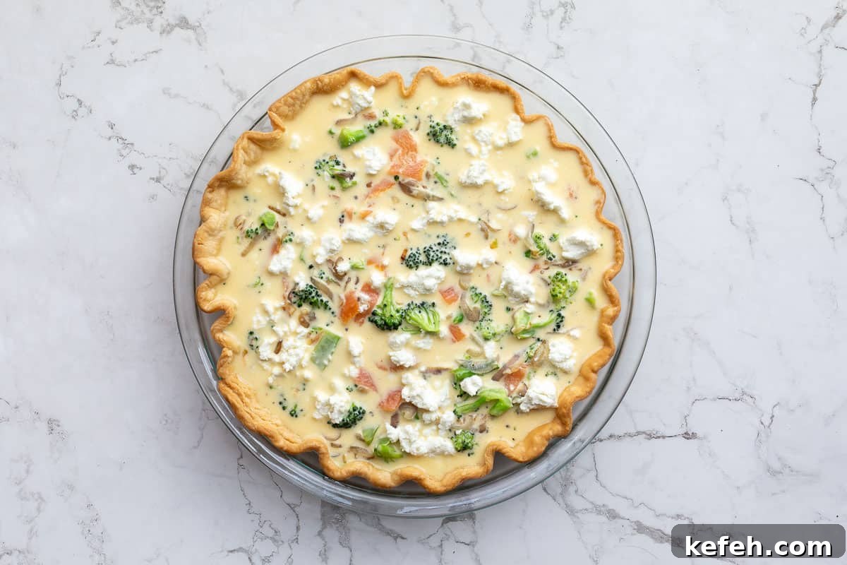 unbaked broccoli and salmon quiche in pie pan.