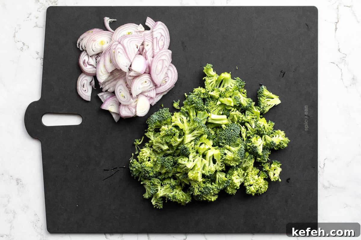 sliced shallots and chopped broccoli on cutting board.