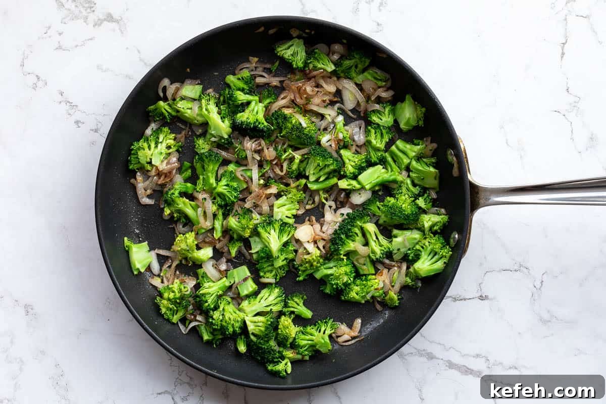 chopped broccoli and shallots sautéed in skillet.