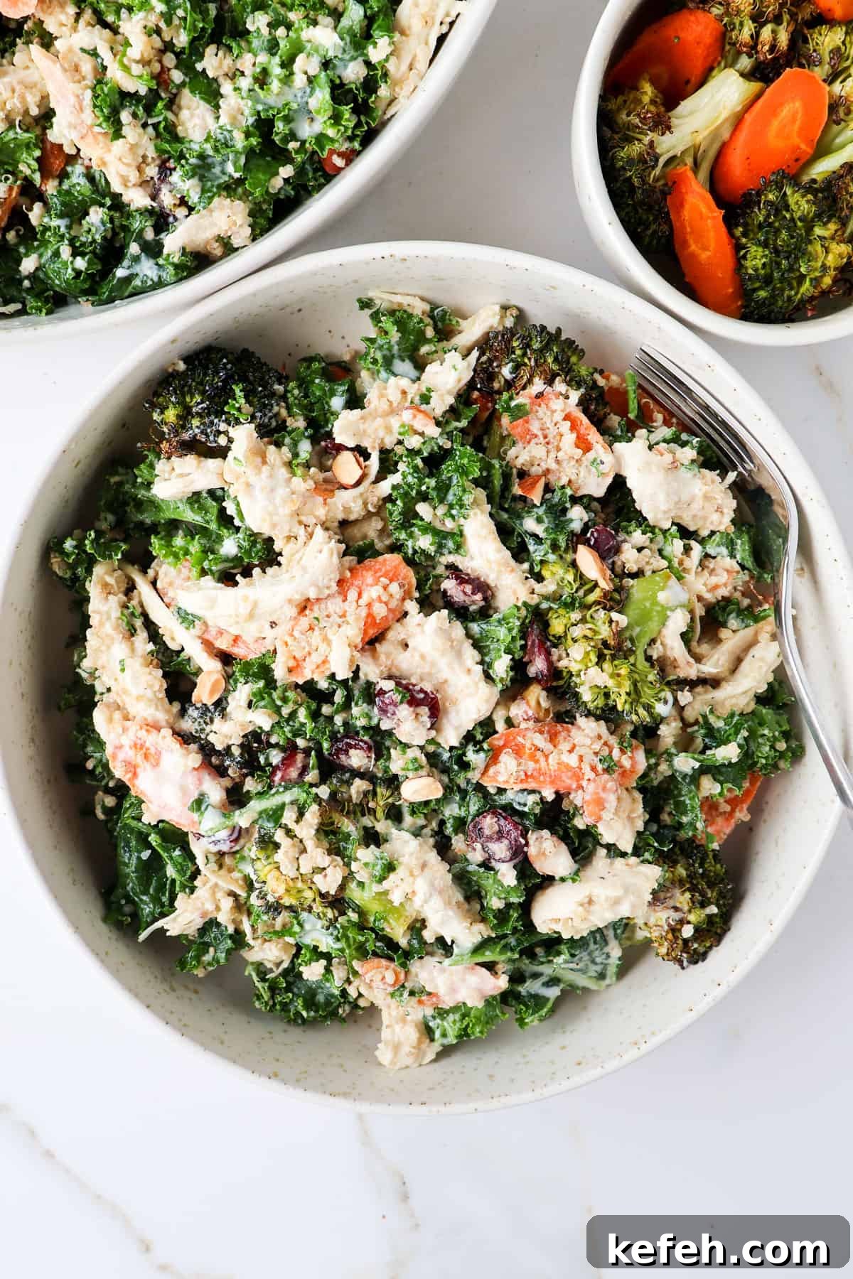 Chicken, broccoli and kale salad served in a bowl with a fork.