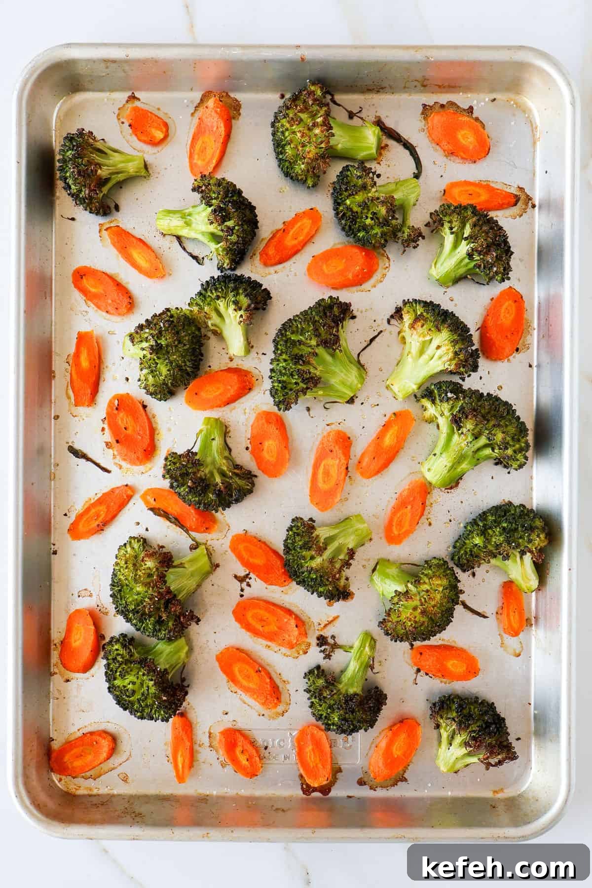 Broccoli and carrots on baking sheet.