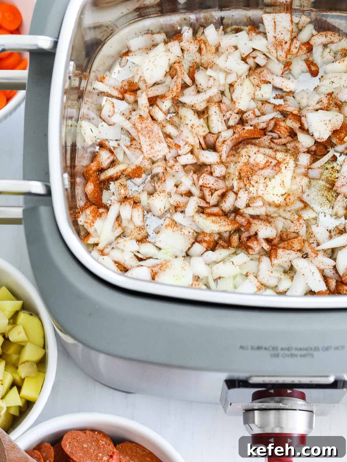 Chopped onions with butter and seasoning in a skillet.