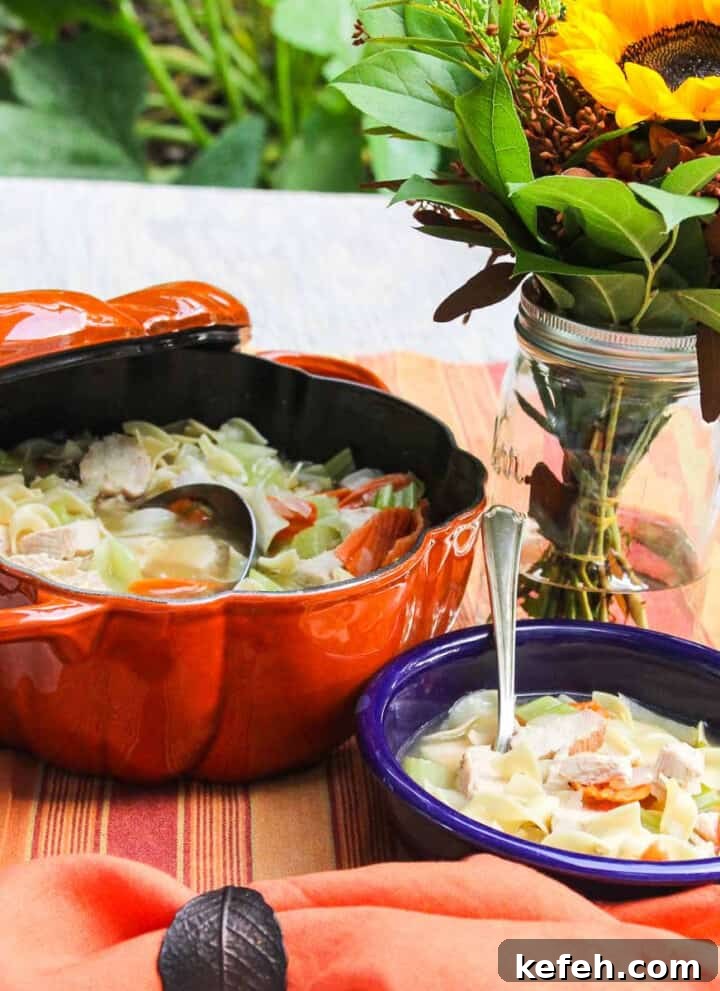 A blue bowl filled with homemade chicken noodle soup.