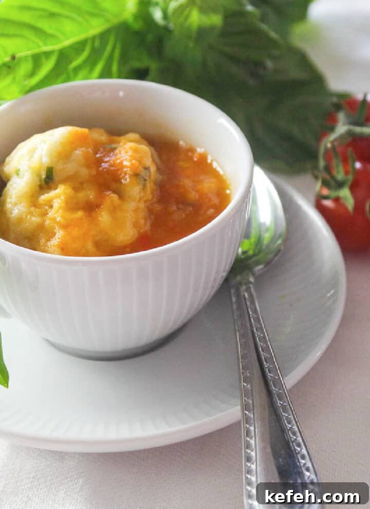 A bowl of tomato soup garnished with fresh basil.