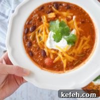 Turkey Taco Chili Soup Recipe — Hearty Weeknight Meal 11 hand holding bowl of skinny turkey chili