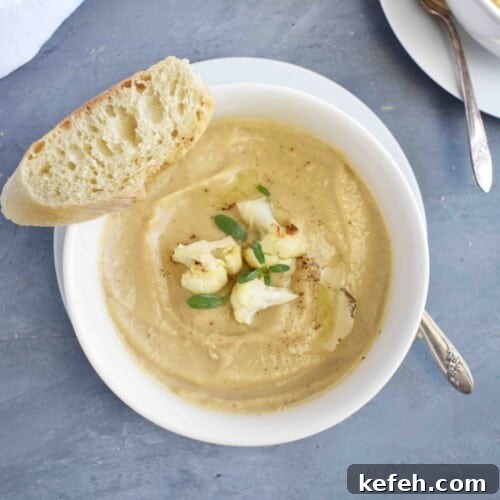 bowl of cauliflower soup with bread on side
