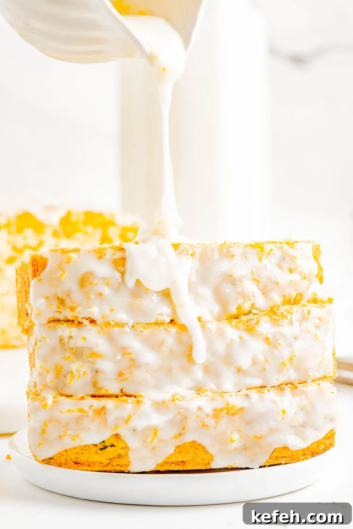 A stack of glazed lemon zucchini bread slices on a plate. 