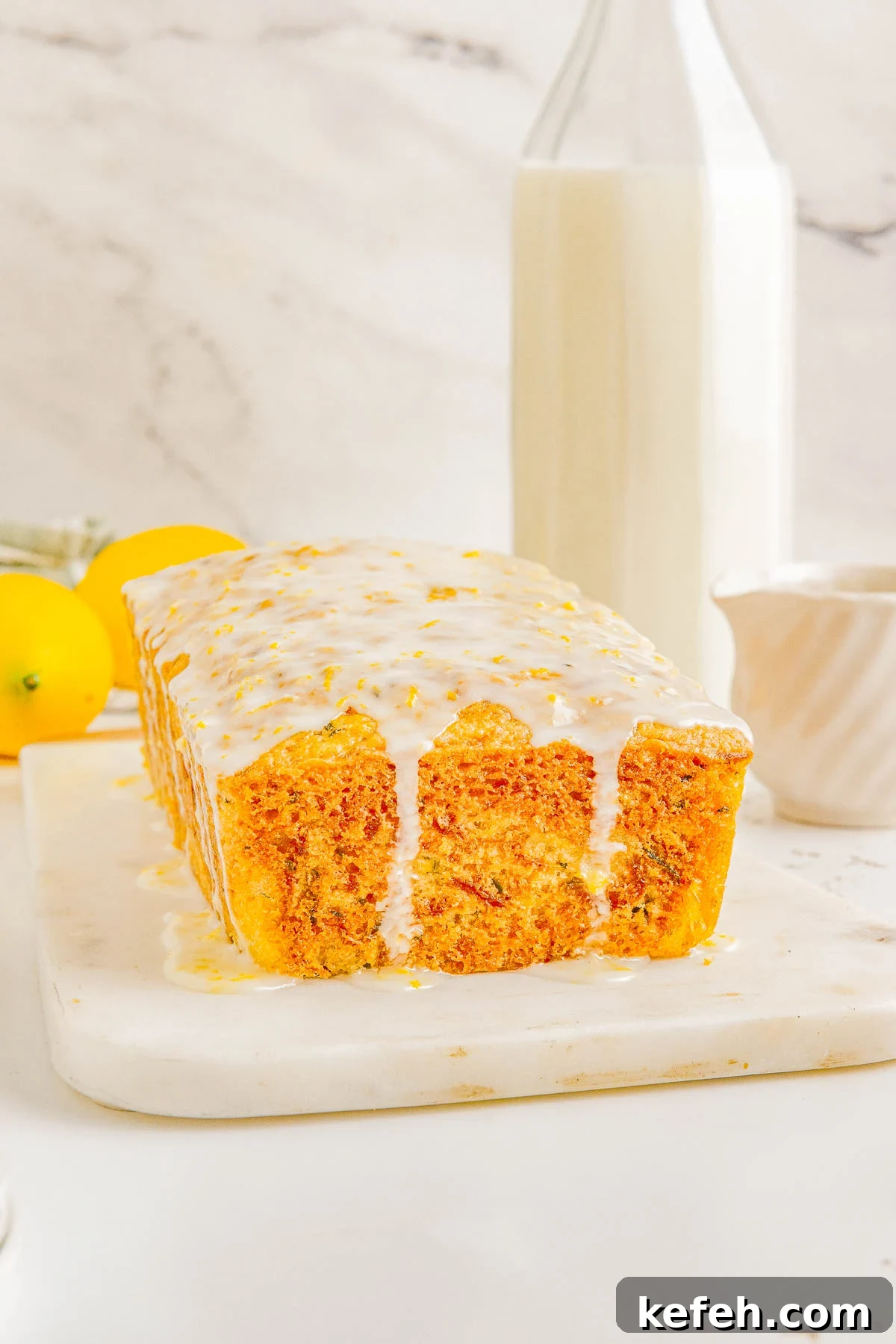 Glazed Lemon Zucchini Bread on a cutting board. 