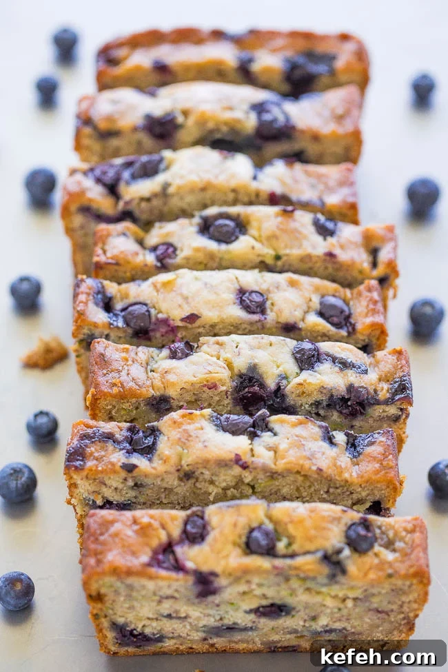 sliced loaf of Blueberry Banana Zucchini Bread on countertop. 