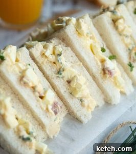 egg mayo tea sandwiches across wooden board