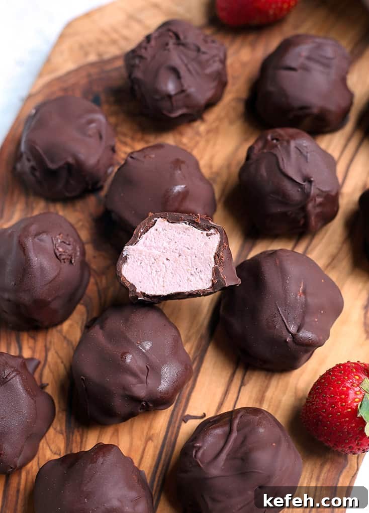 No-Bake Paleo Strawberry Cheesecake Bites Recipe 2 vegan paleo strawberry cheesecake bites on a cutting board with the inside of one showing