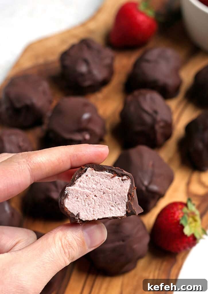 No-Bake Paleo Strawberry Cheesecake Bites Recipe 4 a hand holding a paleo strawberry cheesecake bite