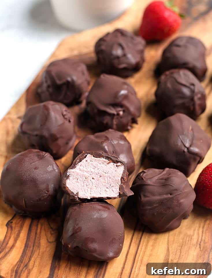 No-Bake Paleo Strawberry Cheesecake Bites Recipe 6 a plate of paleo strawberry cheesecake bites with one cut open to show inside