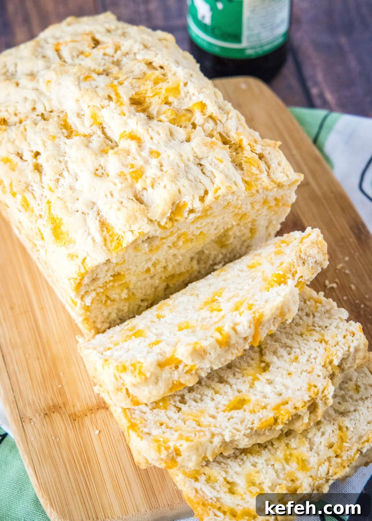 This easy cheddar beer bread recipe is moist, soft, full of beer and cheese flavors, and so quick and easy to make at home. Overhead view of a loaf of beer bread with three pieces cut off