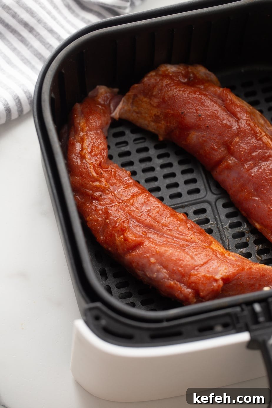 Crispy Air Fryer Pork Tenderloin with Garlic Herb Rub 8 Two pork tenderloins in a basket style air fryer.