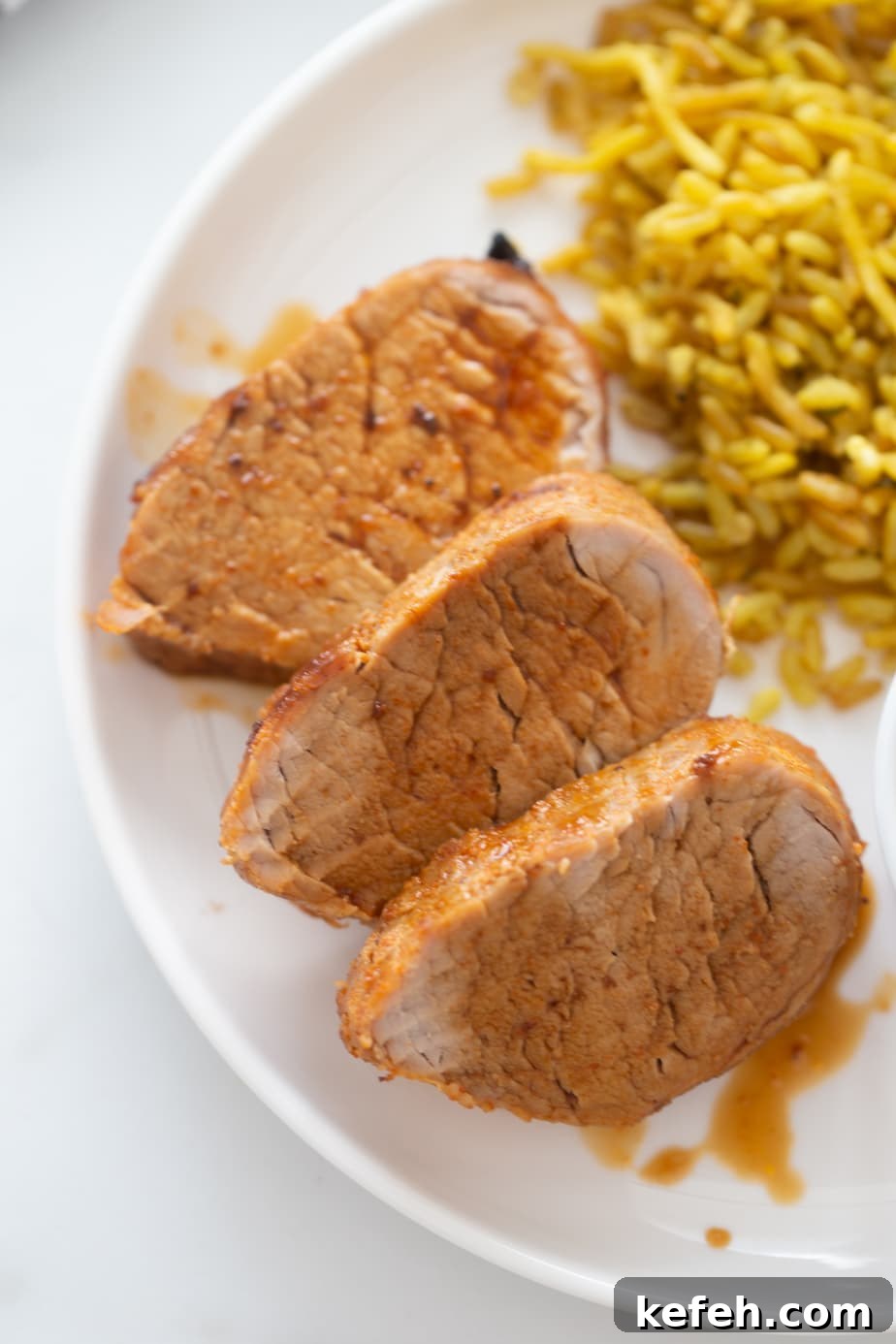 Crispy Air Fryer Pork Tenderloin with Garlic Herb Rub 10 Overhead image of sliced pork tenderloin with delicious au jus drizzled over top!