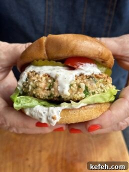 hands holding salmon burger