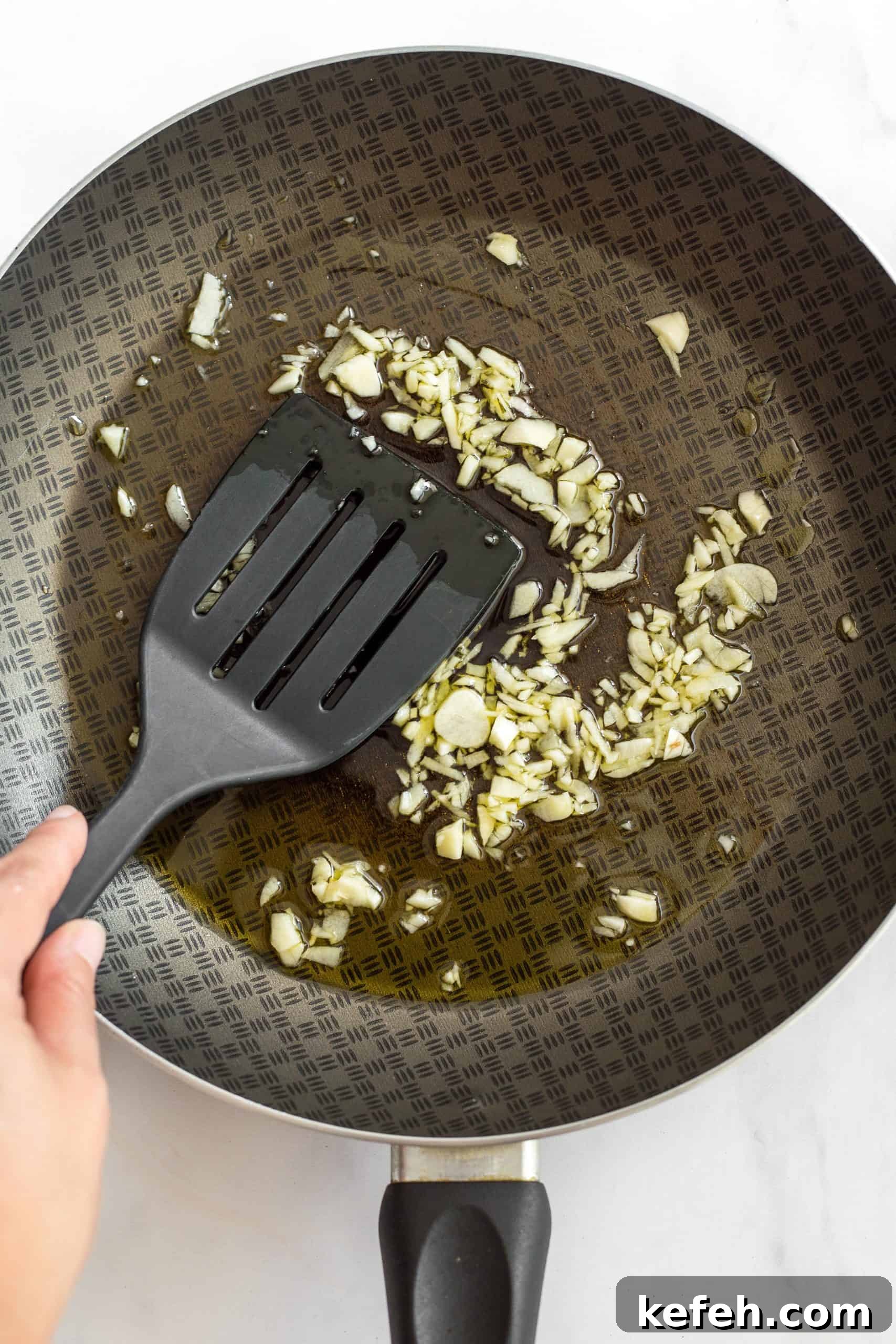 Creamy Gluten-Free Potato Bake (Dairy-Free, Vegan) Sautéing minced garlic in a skillet.