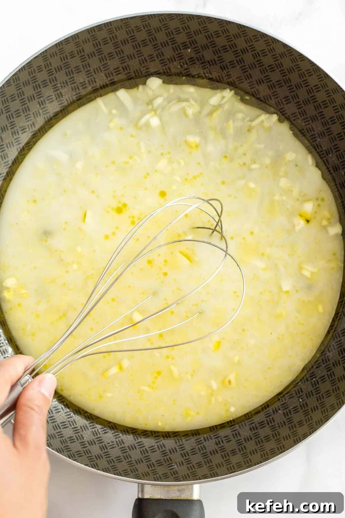 Gluten and Dairy-Free Scalloped Potatoes (Vegan) Whisking minced garlic in pale yellow liquid mixture.