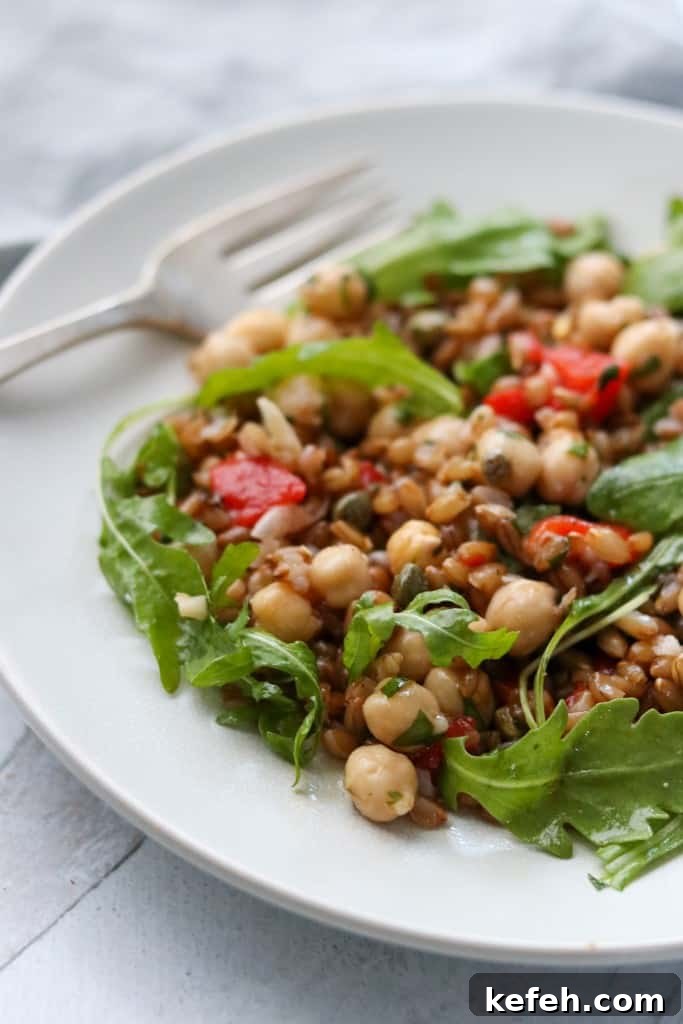 Rye Berry Salad with Chickpeas, Roasted Red Peppers and Arugula 8 Rye berry and chickpea salad on a plate with a fork