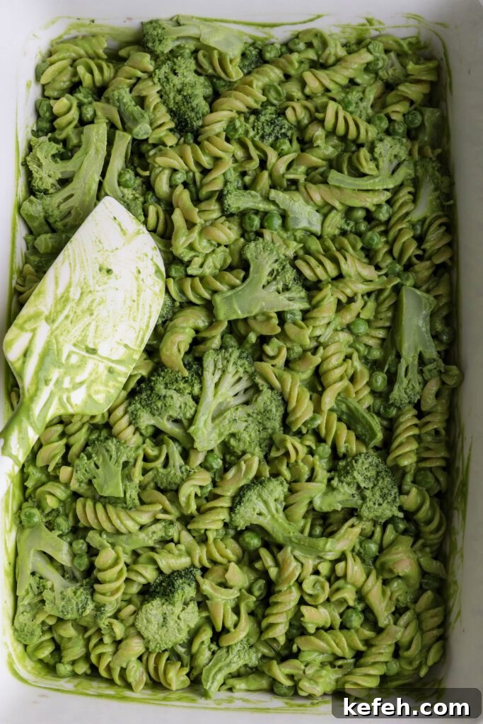 Baked Green Pesto Pasta Casserole Recipe 5 Green Pesto Pasta Casserole mixed together in casserole dish with spatula