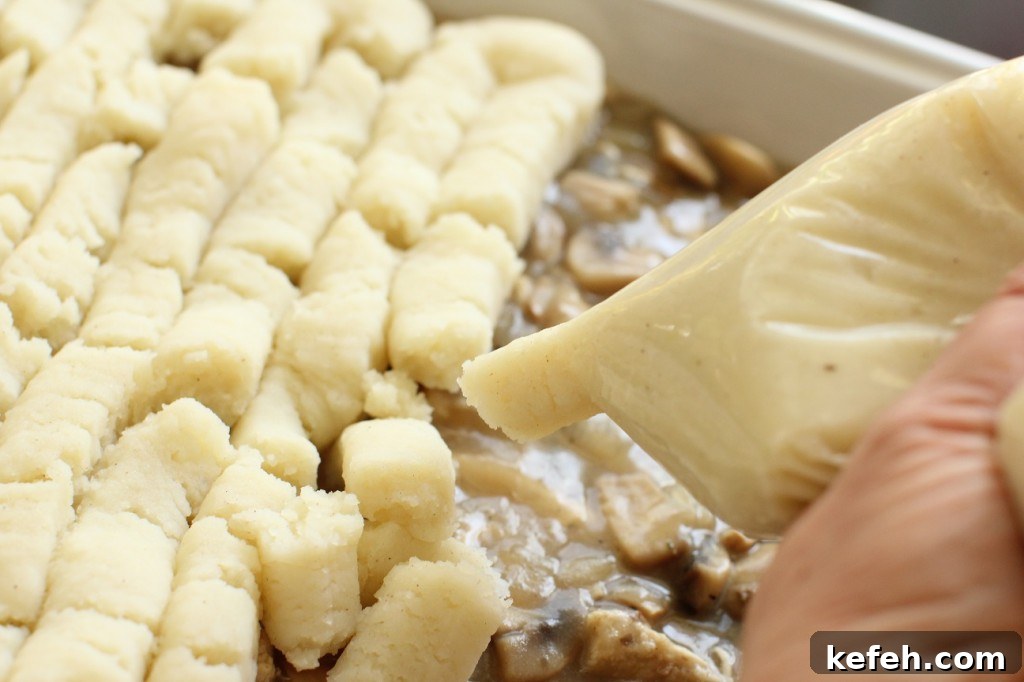 Cheesy Turkey and Potato Puff (Cottage Pie Style) 6 piping the potatoes onto the turkey and potato puff (cottage pie)