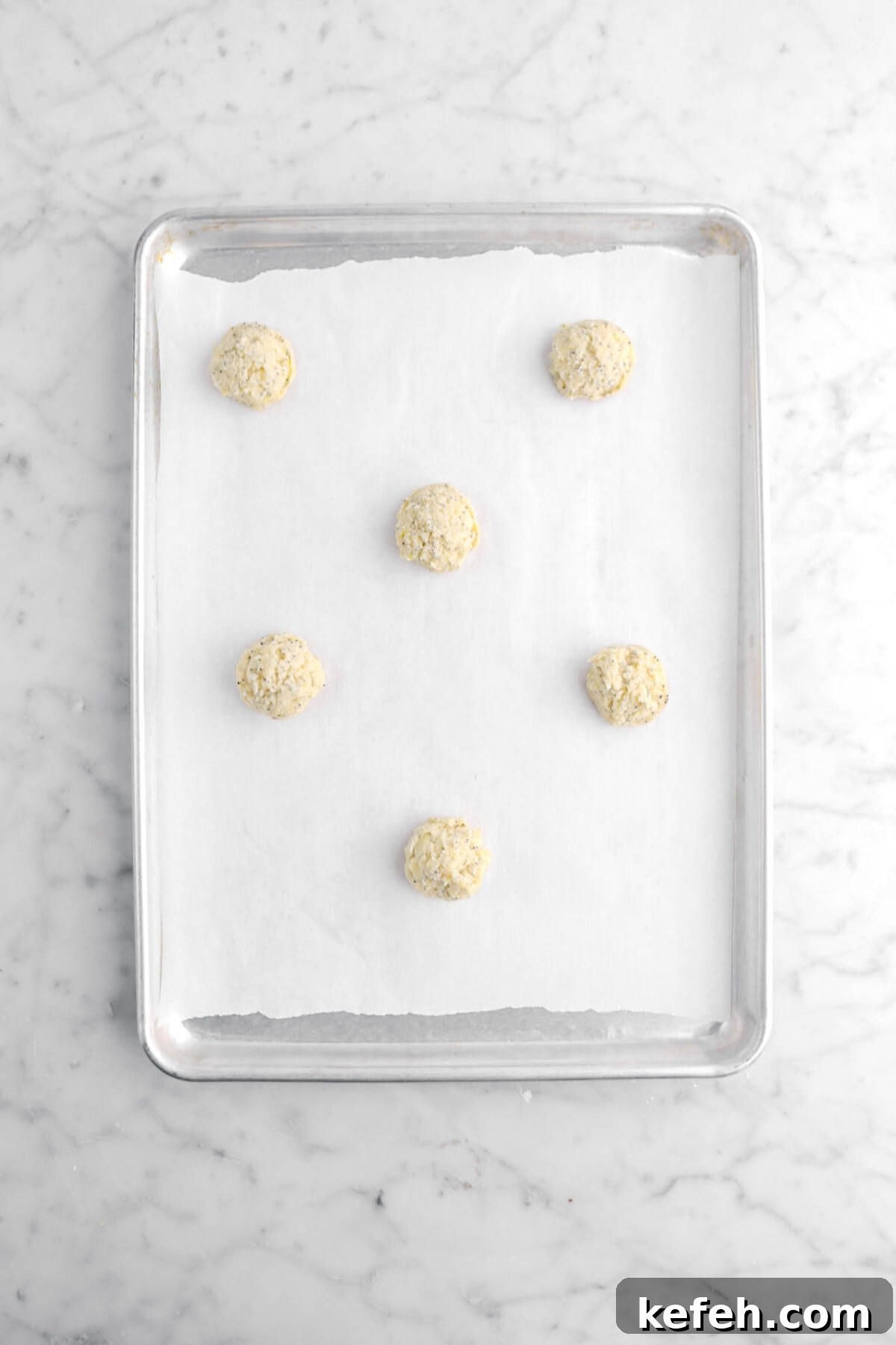 Lemon Poppy Seed Cookies with Lemon Drizzle Recipe 9 six cookie dough balls on lined sheet pan.