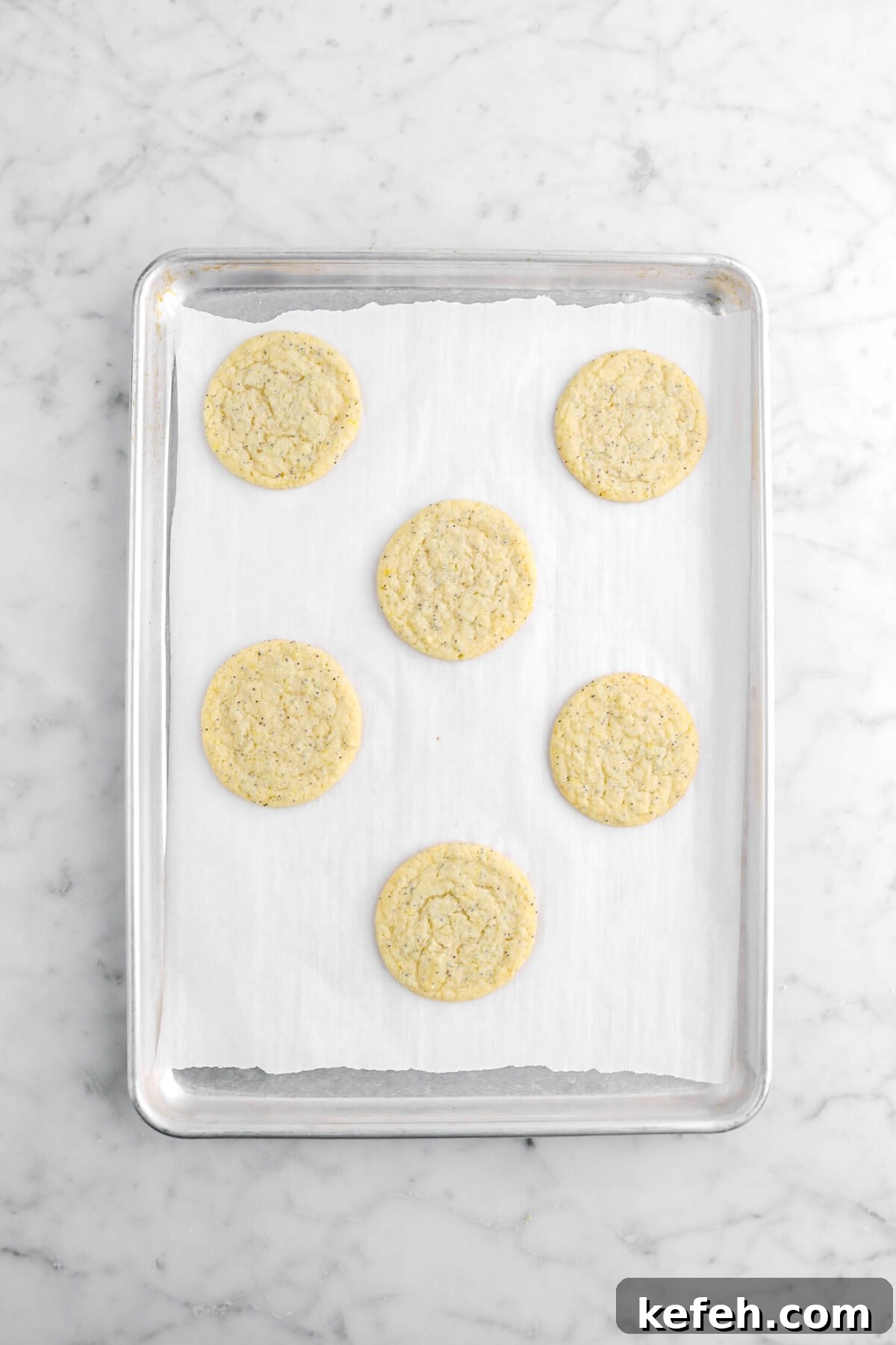 Lemon Poppy Seed Cookies with Lemon Drizzle Recipe 10 baked lemon poppy seed cookies on lined sheet pan.