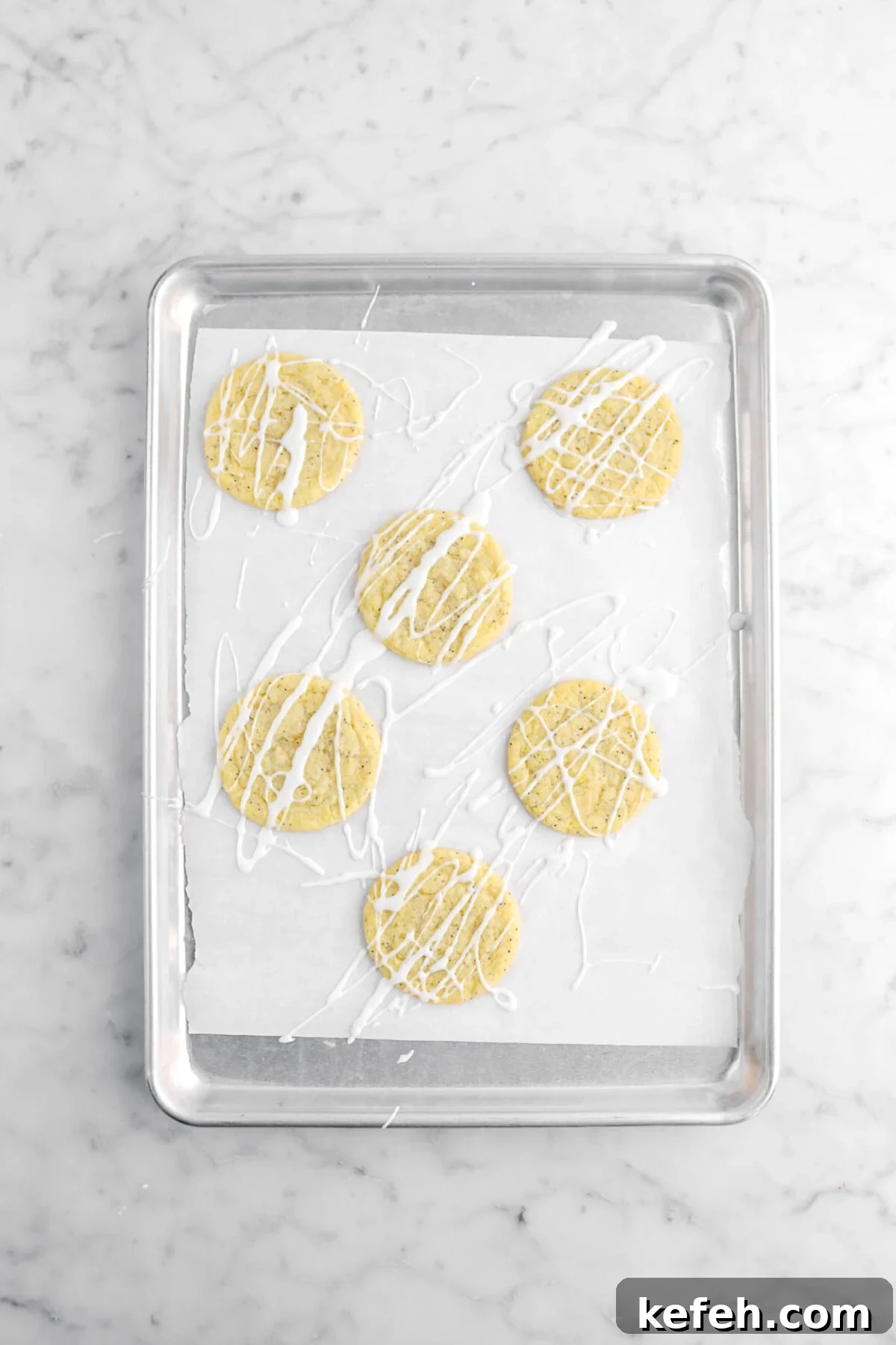 Lemon Poppy Seed Cookies with Lemon Drizzle Recipe 11 six cookies on lined sheet pan with icing drizzled over each cookie.