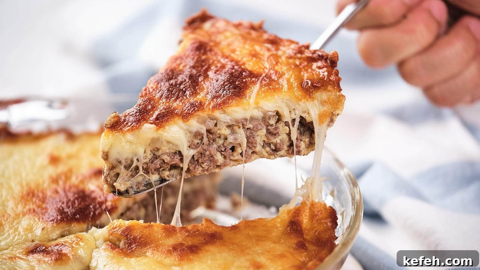 25 Low-Carb Dinners Even Carb Lovers Can't Resist 2 A slice of cheeseburger pie being lifted, showing layers of meat and melted cheese.