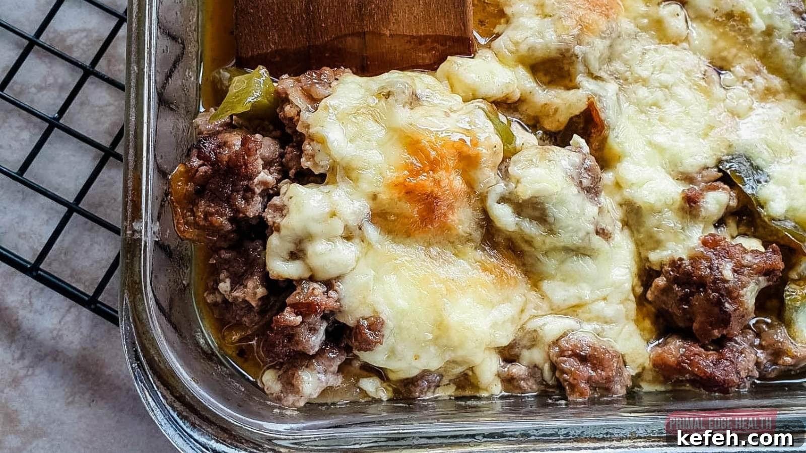 25 Low-Carb Dinners Even Carb Lovers Can't Resist 11 Image shows a wooden spatula cutting philly cheesesteak casserole from baking dish.