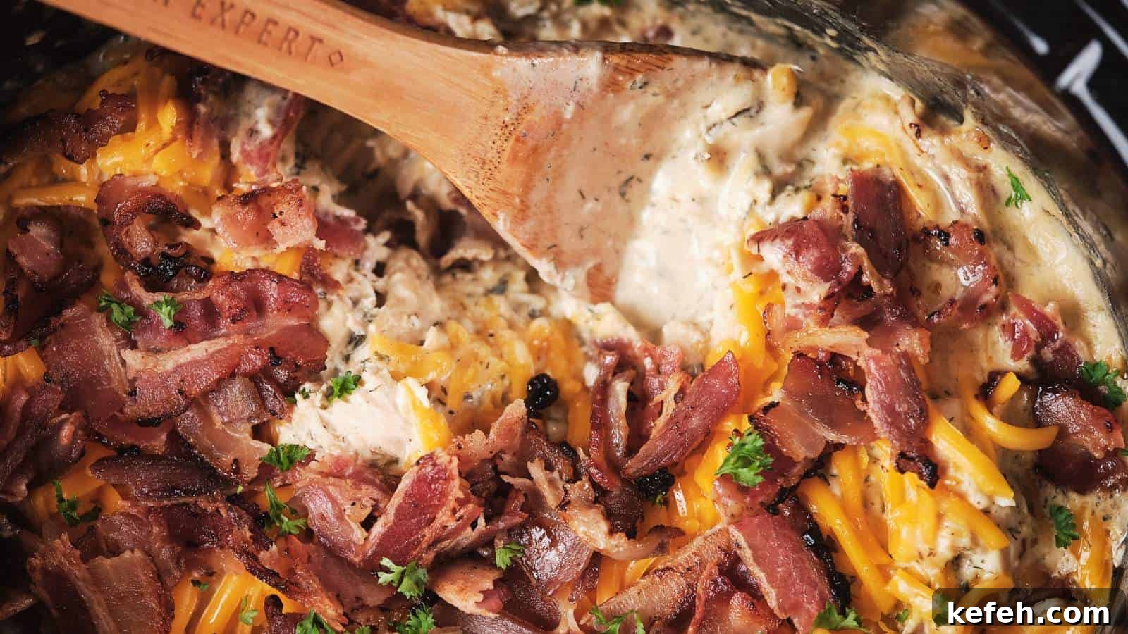 25 Low-Carb Dinners Even Carb Lovers Can't Resist 12 A close-up of slow-cooker-crack-chicken being stirred with a wooden spoon.