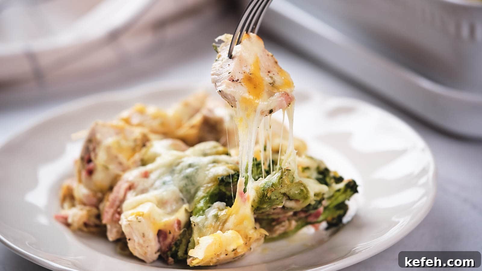 25 Low-Carb Dinners Even Carb Lovers Can't Resist 16 A fork lifting a portion of chicken bacon ranch casserole from a white plate.