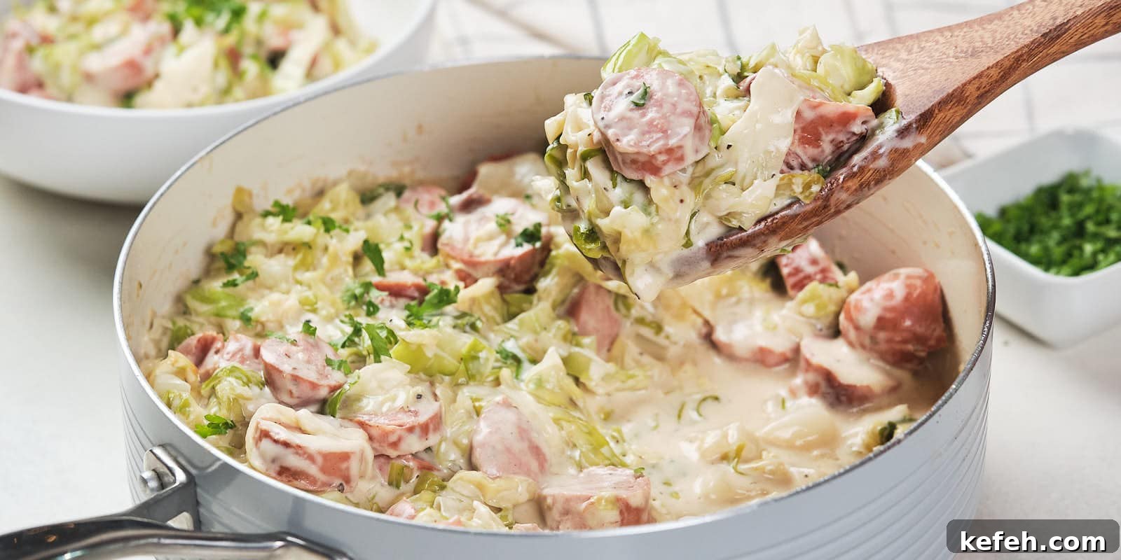 25 Low-Carb Dinners Even Carb Lovers Can't Resist 23 A skillet containing a creamy cabbage and sausage alfredo garnished with herbs.