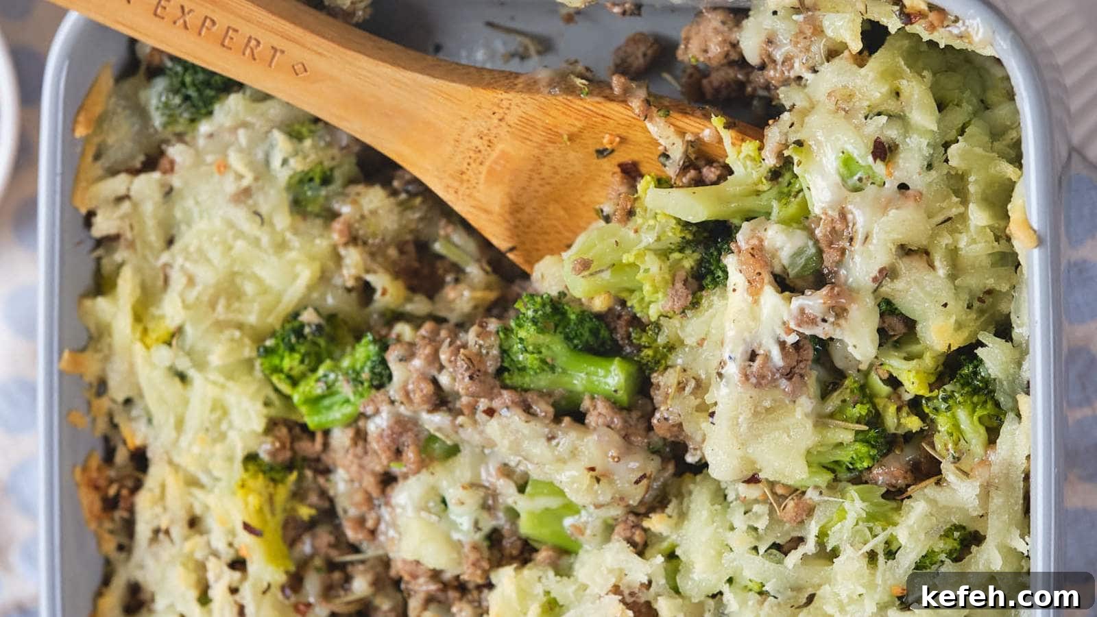 25 Low-Carb Dinners Even Carb Lovers Can't Resist 24 A baked casserole dish with ground beef and broccoli casserole and a wooden spoon.
