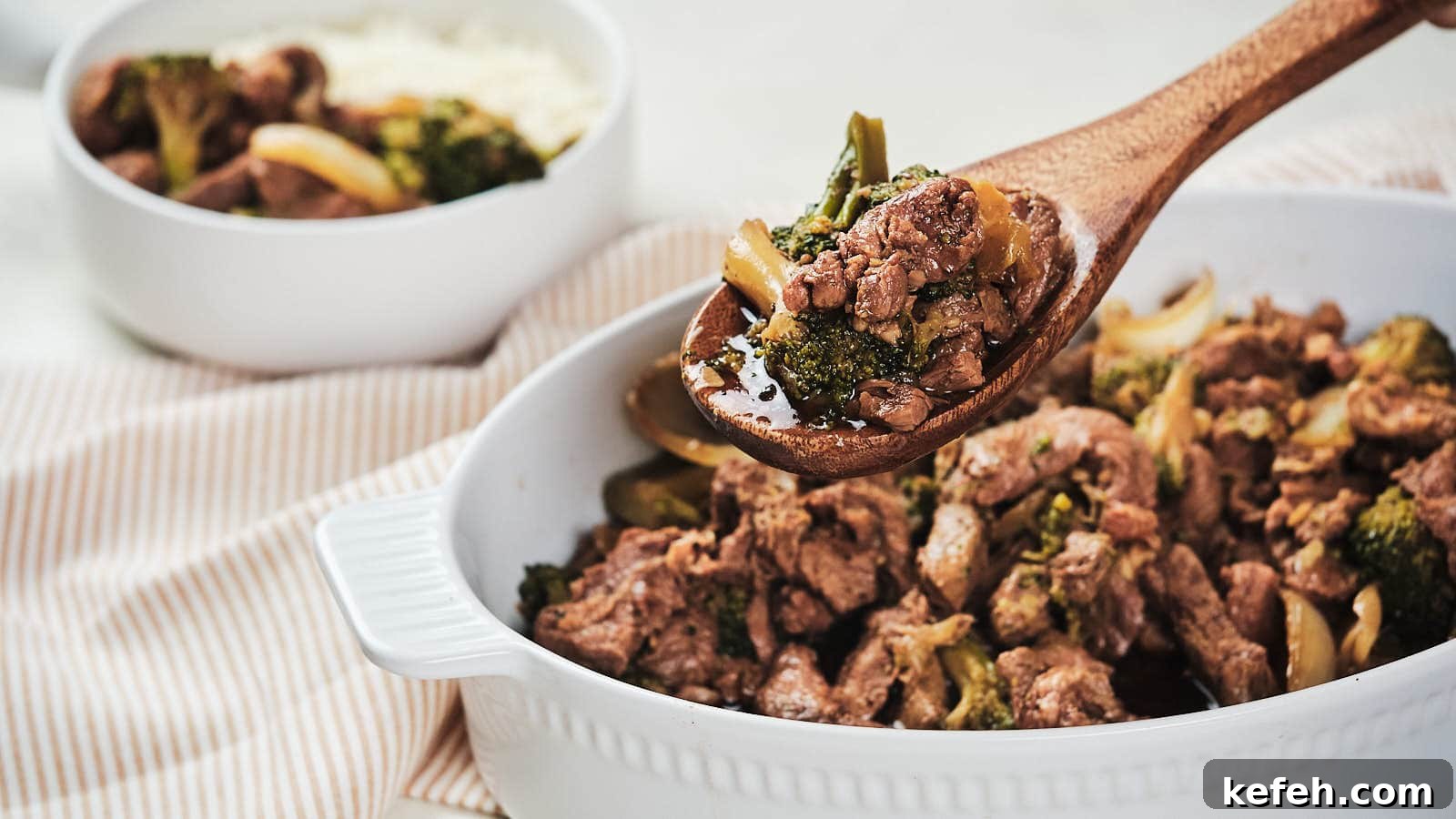 25 Low-Carb Dinners Even Carb Lovers Can't Resist 9 Slow cooker beef and broccoli with onion in brown bowl.