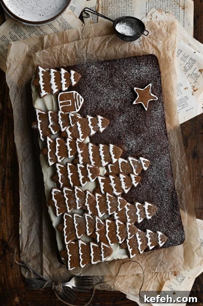 Classic Moist Gingerbread Cake Recipe 11 Gingerbread sheet cake topped with Christmas tree shaped cookies on wood table.